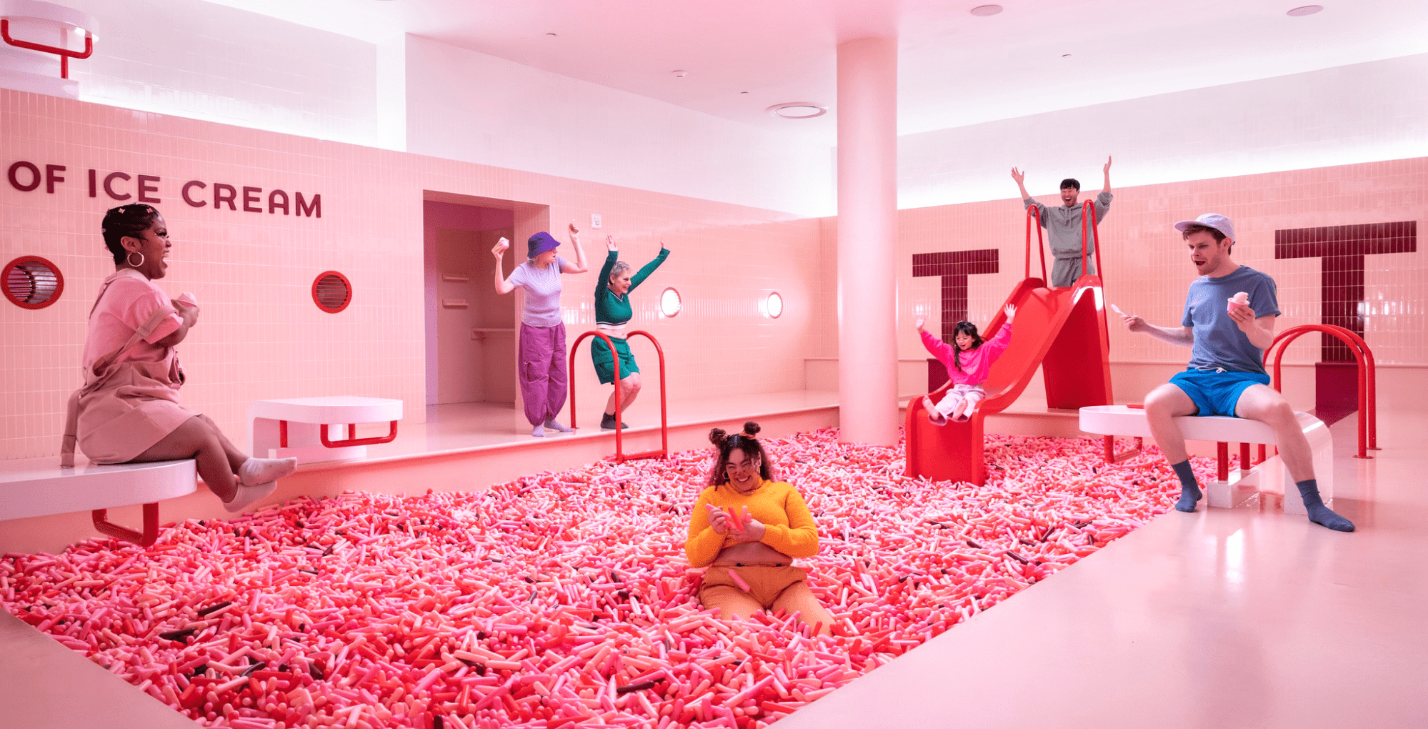 pink ball pit with people playing inside